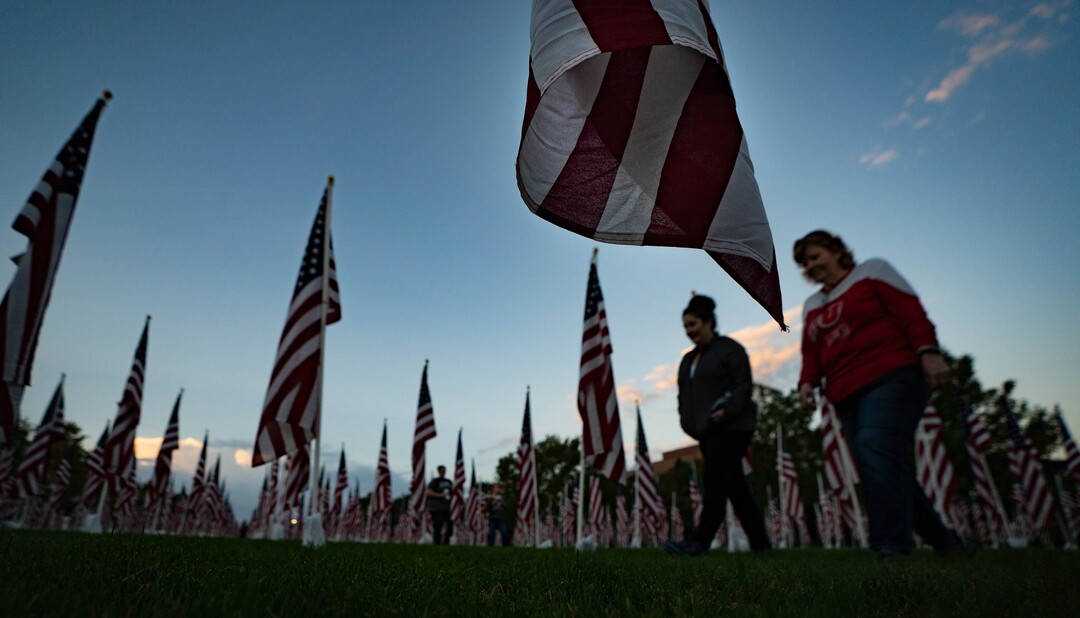 (Francisco Kjolseth | The Salt Lake Tribune) The sun rises on Saturday, Sept. 11, 2021, as people visit the Utah Healing Field in Sandy, part of the nonprofit Colonial Flag Foundation, who posted 3,000 flags to honor the fallen. The display is free to the public and open now through Sept. 13.