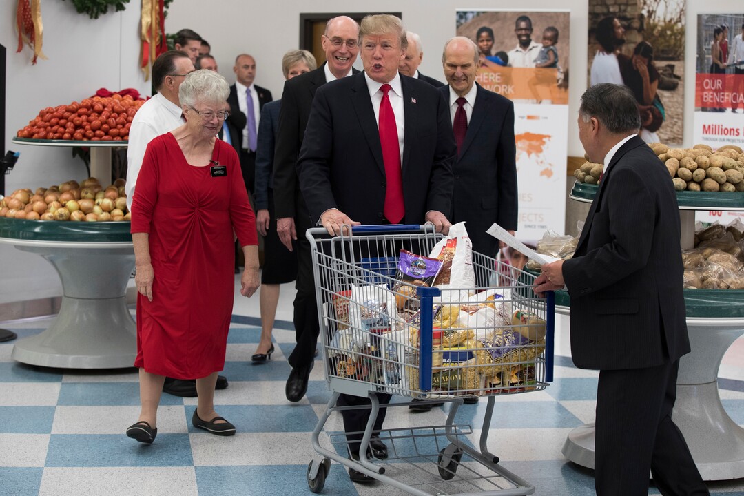 President Donald Trump pushes a cart during a tour of the Church of Jesus Christ of Latter-Day Saints Welfare Square food distribution center, Monday, Dec. 4, 2017, in Salt Lake City. (AP Photo/Evan Vucci)