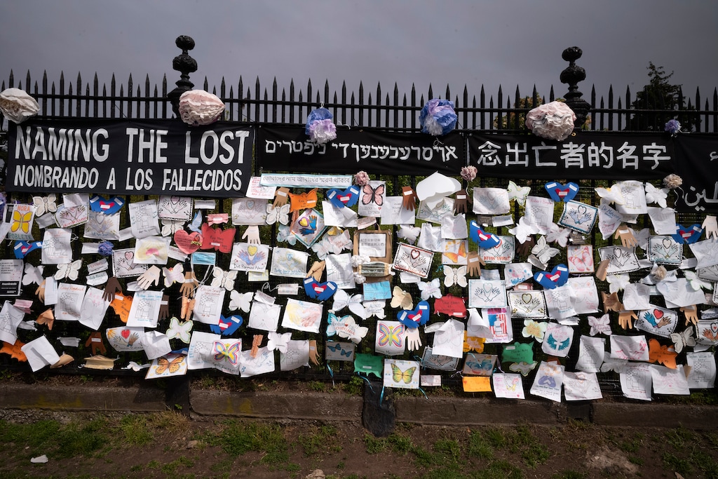 (Mark Lennihan | The Associated Press) A fence outside Brooklyn's Green-Wood Cemetery is adorned Thursday, May 28, 2020, with tributes to victims of COVID-19 in New York. The memorial is part of the Naming the Lost project which attempts to humanize the victims who are often just listed as statistics. The wall features banners that say "Naming the Lost" in six languages — English, Spanish, Mandarin, Arabic, Hebrew, and Bengali. Some worry a large new wave of coronavirus might occur in the fall or winter of 2020 — after schools reopen, the weather turns colder and less humid, and people huddle inside more.