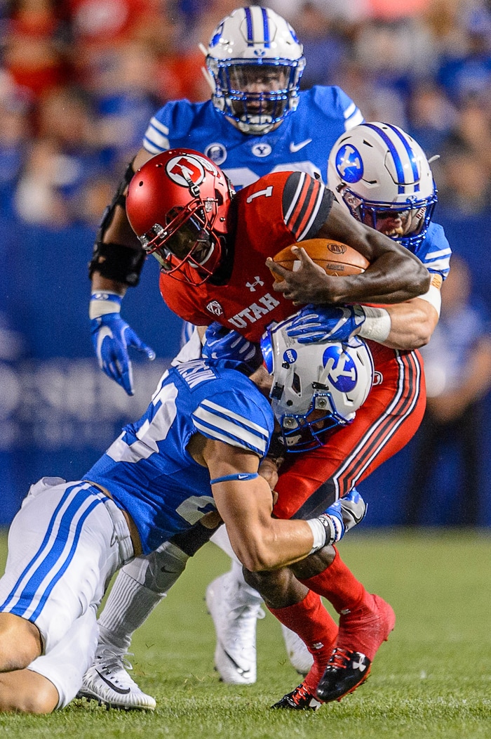 (Trent Nelson | The Salt Lake Tribune)  Utah Utes quarterback Tyler Huntley (1) is brought by Brigham Young Cougars defensive back Zayne Anderson (23) and Brigham Young Cougars linebacker Matt Hadley (2) down after a run as BYU hosts Utah, NCAA football in Provo, Saturday September 9, 2017.