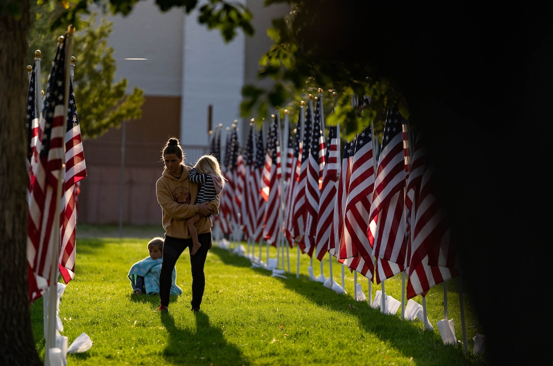 (Francisco Kjolseth | The Salt Lake Tribune) The sun rises on Saturday, Sept. 11, 2021, as people visit the Utah Healing Field in Sandy, part of the nonprofit Colonial Flag Foundation, who posted 3,000 flags to honor the fallen. The display is free to the public and open now through Sept. 13.