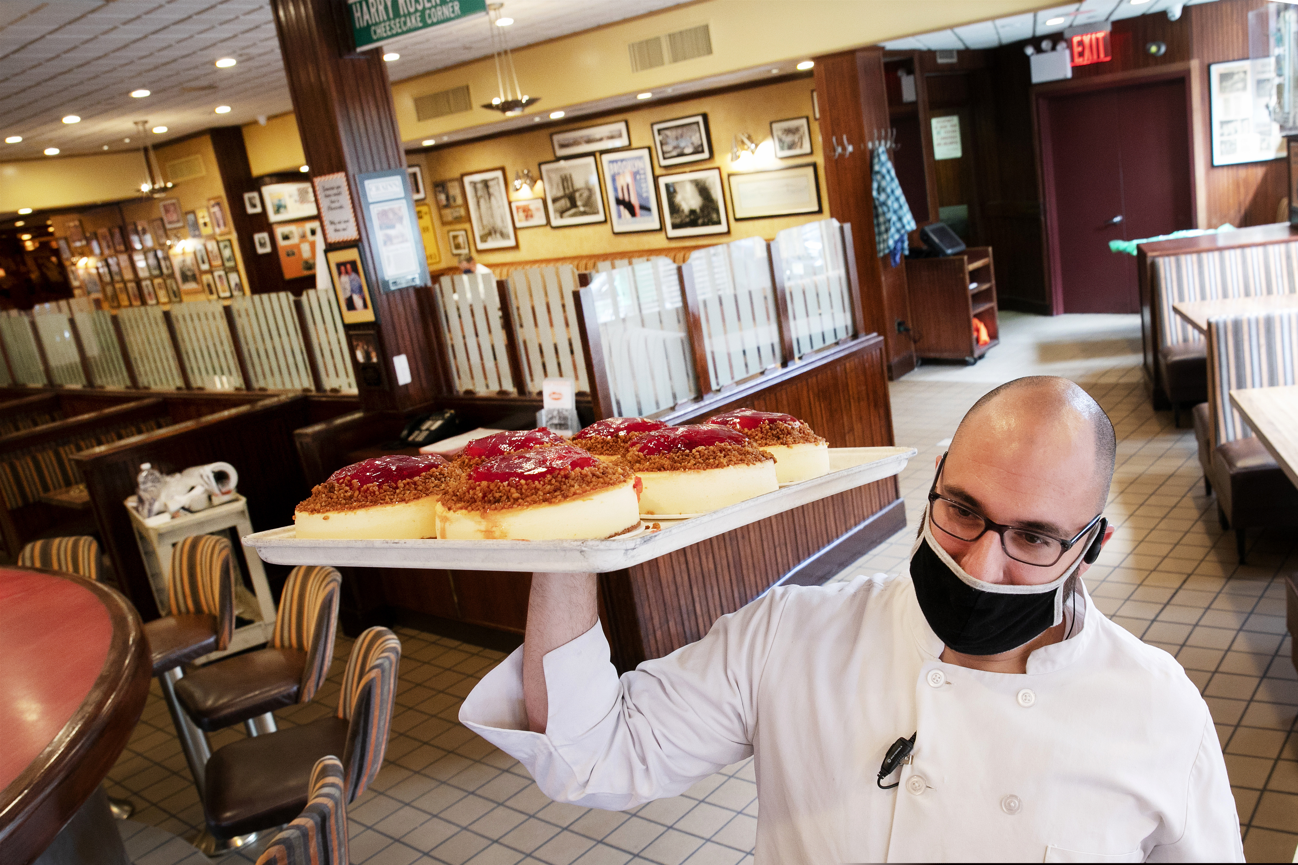 (Mark Lennihan | AP file photo)  William McCarthy, the director of operations at Junior's Restaurant, delivers a tray of cheesecakes to a front counter, Monday, June 29, 2020, in New York.