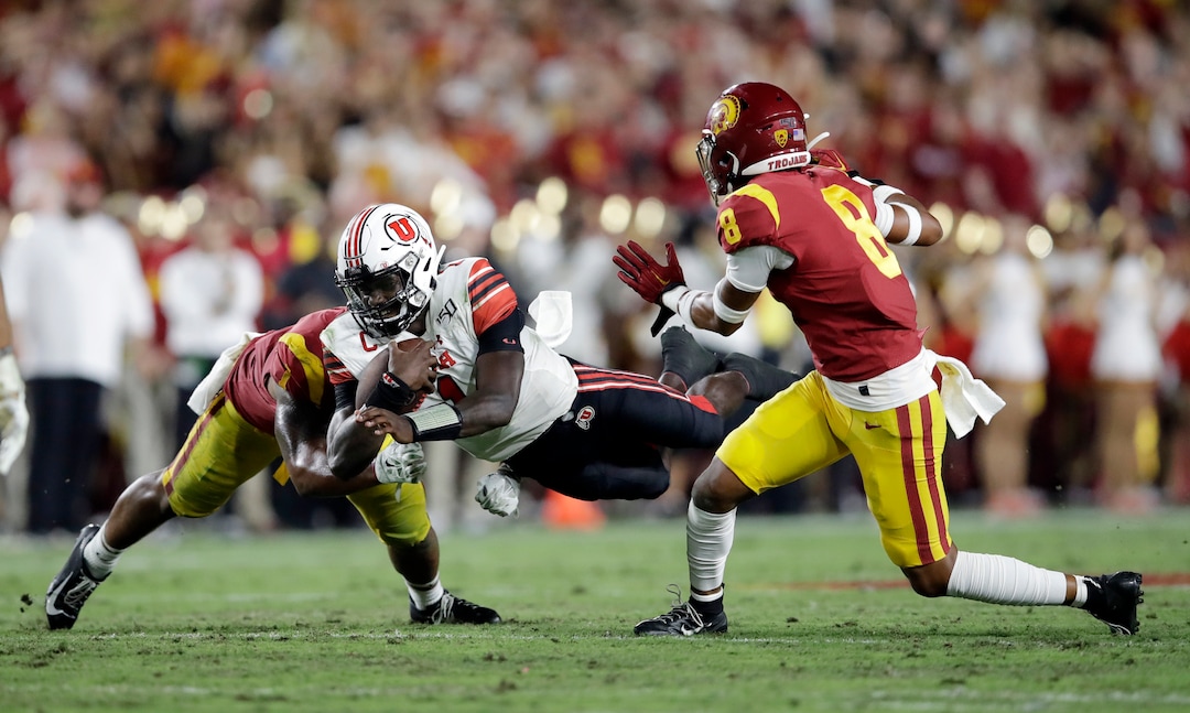 Utah quarterback Tyler Huntley, center, lunges for yardage next to Southern California cornerback Chris Steele (8) during the first half of an NCAA college football game Friday, Sept. 20, 2019, in Los Angeles. (AP Photo/Marcio Jose Sanchez)