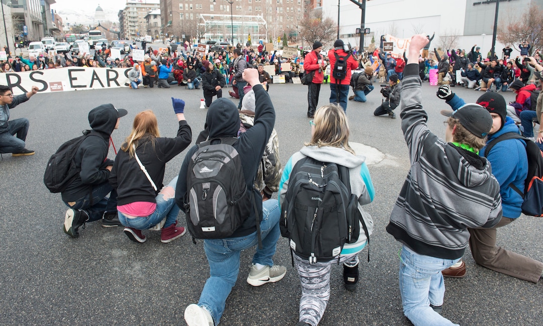 (Rick Egan  |  The Salt Lake Tribune)  Protesters kneel down as they block traffic on State Street, during President Trump's visit to Salt Lake CIty, Monday, December 4, 2017.