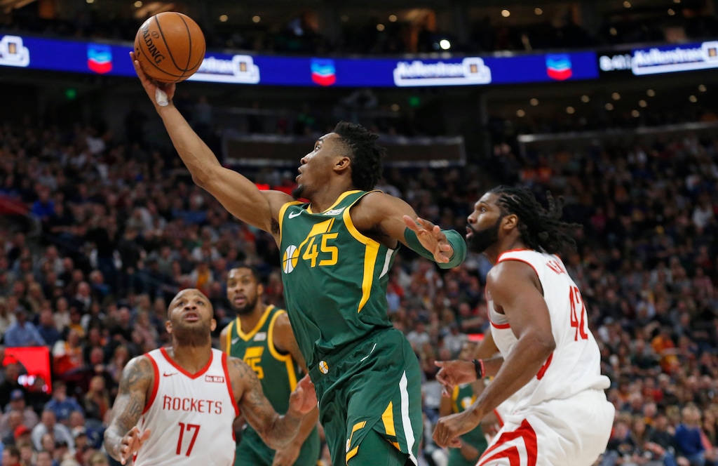 Utah Jazz guard Donovan Mitchell (45) lays the ball up as Houston Rockets' PJ Tucker (17) and Nene Hilario (42) defend during the second half of an NBA basketball game Saturday, Feb. 2, 2019, in Salt Lake City. (AP Photo/Rick Bowmer)