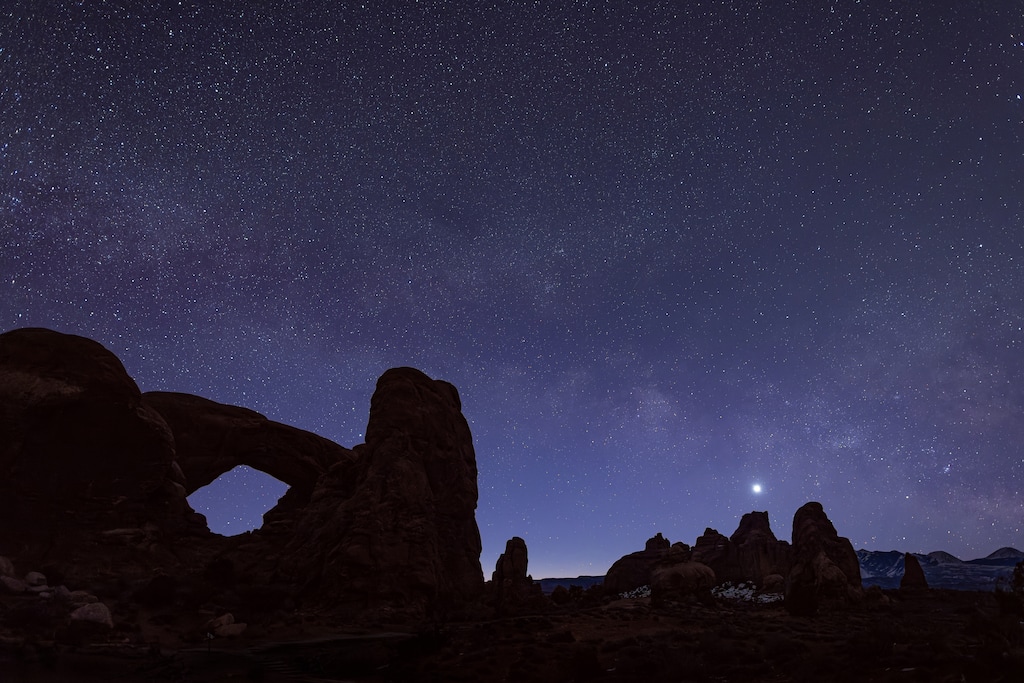 (John Burcham | The New York Times) Venus rises amid a blanket of stars in Arches National Park in February 2022.