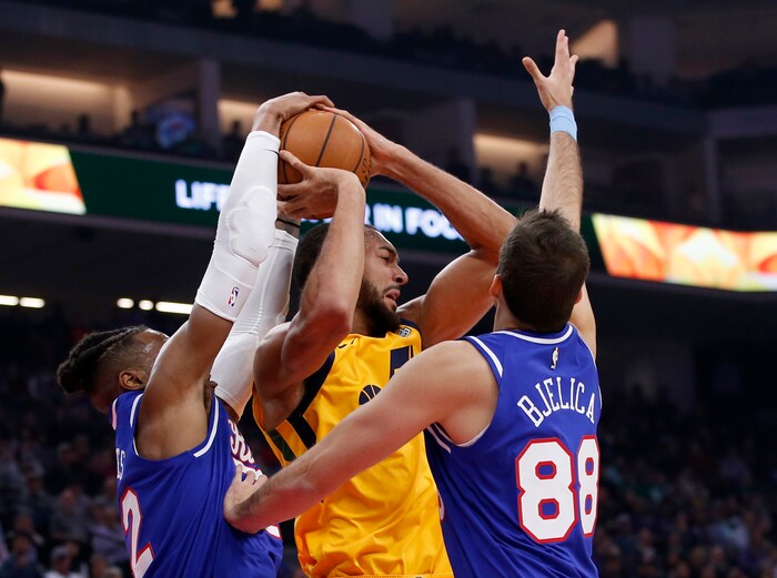 Utah Jazz center Rudy Gobert, center, works for a rebound between Sacramento Kings Richaun Holmes, left and Nemanja Bjelica, right, during the first quarter of an NBA basketball game in Sacramento, Calif., Friday, Nov. 1, 2019. (AP Photo/Rich Pedroncelli)