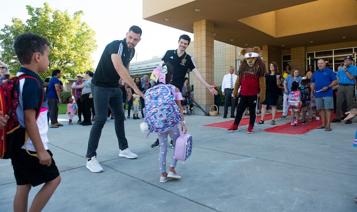 (Rick Egan | The Salt Lake Tribune) Real Salt Lake players and mascot Leo the Lion high-five students as they walk the red carpet on the first day of school at Copperview Elementary School in Midvale, Monday, Aug. 19, 2019.