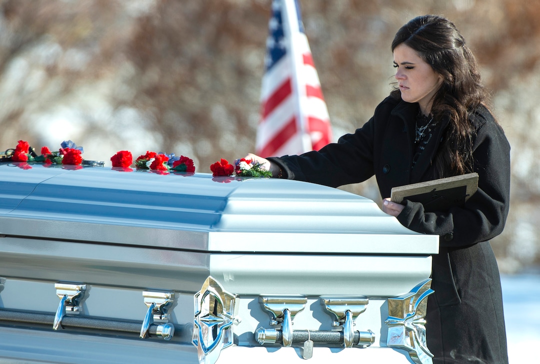 (Rick Egan  |  The Salt Lake Tribune)   McKenzie Fuchigami, puts a flower on the casket in the Brigham City Cemetery, after the funeral for her husband Kirk T. Fuchigami Jr. who was killed last month in Afghanistan, Monday, Dec. 9, 2019.