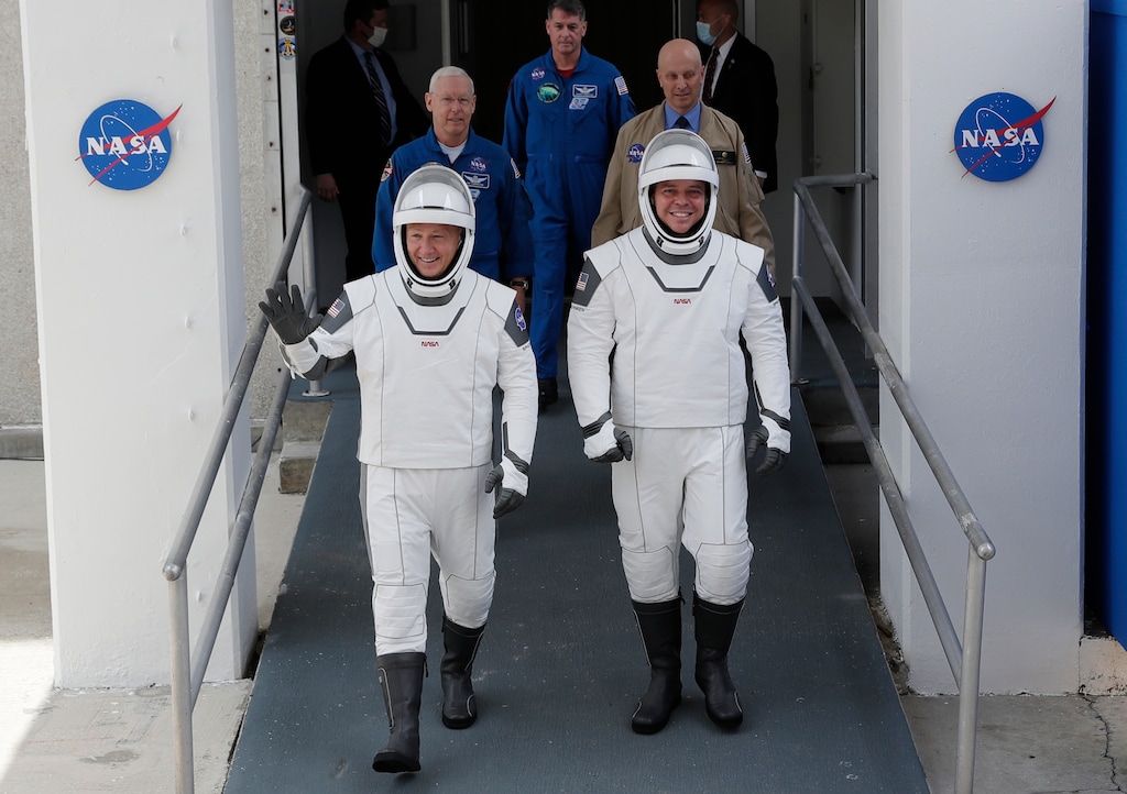 (John Raoux | AP) NASA astronauts Douglas Hurley, left, and Robert Behnken wave as they walk out of the Neil A. Armstrong Operations and Checkout Building on their way to Pad 39-A, at the Kennedy Space Center in Cape Canaveral, Fla., Wednesday, May 27, 2020. The two astronauts will fly on a SpaceX test flight to the International Space Station. For the first time in nearly a decade, astronauts will blast into orbit aboard an American rocket from American soil, a first for a private company.