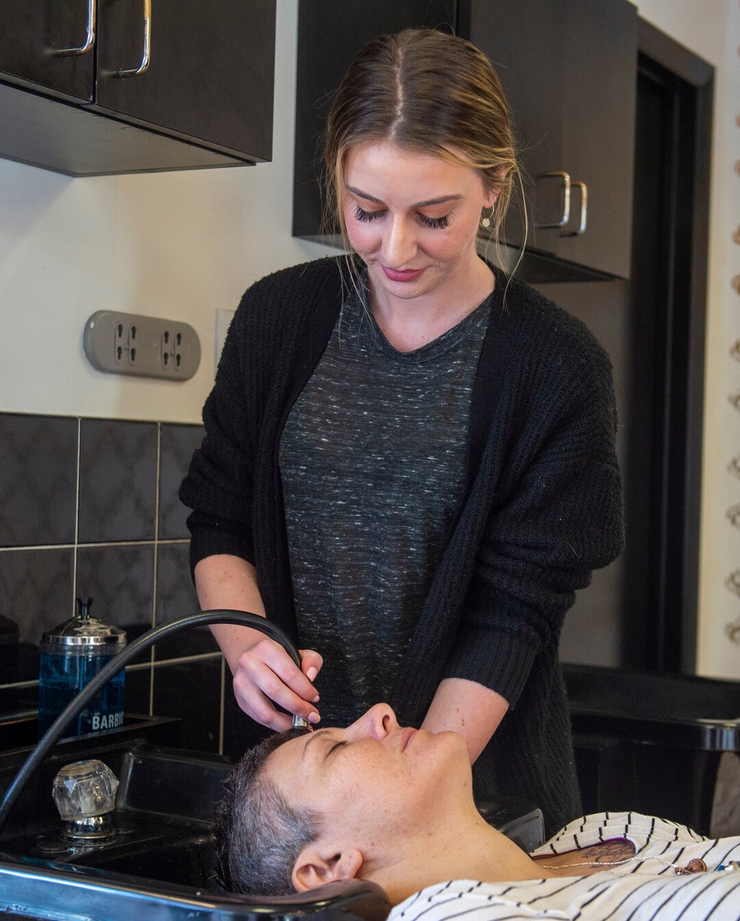 (Rick Egan  |  The Salt Lake Tribune)     Ellen Stephenson rinces Donna May's hair  at Mid City Salon, Saturday, March 21, 2020.