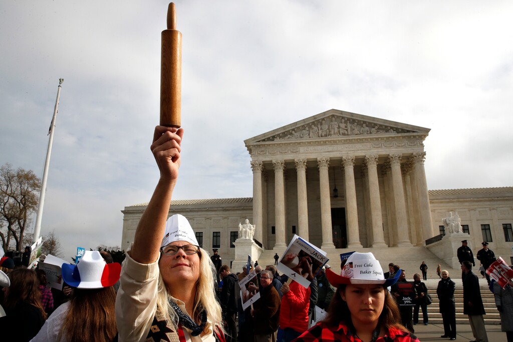 (AP Photo/Jacquelyn Martin) Mary Torres of Falls Church, Va., left, holds a rolling pin up in support of cake artist Jack Phillips, while outside of the Supreme Court with her daughter Maria Torres, right, Tuesday, Dec. 5, 2017, during arguments the 'Masterpiece Cakeshop v. Colorado Civil Rights Commission' case in Washington.