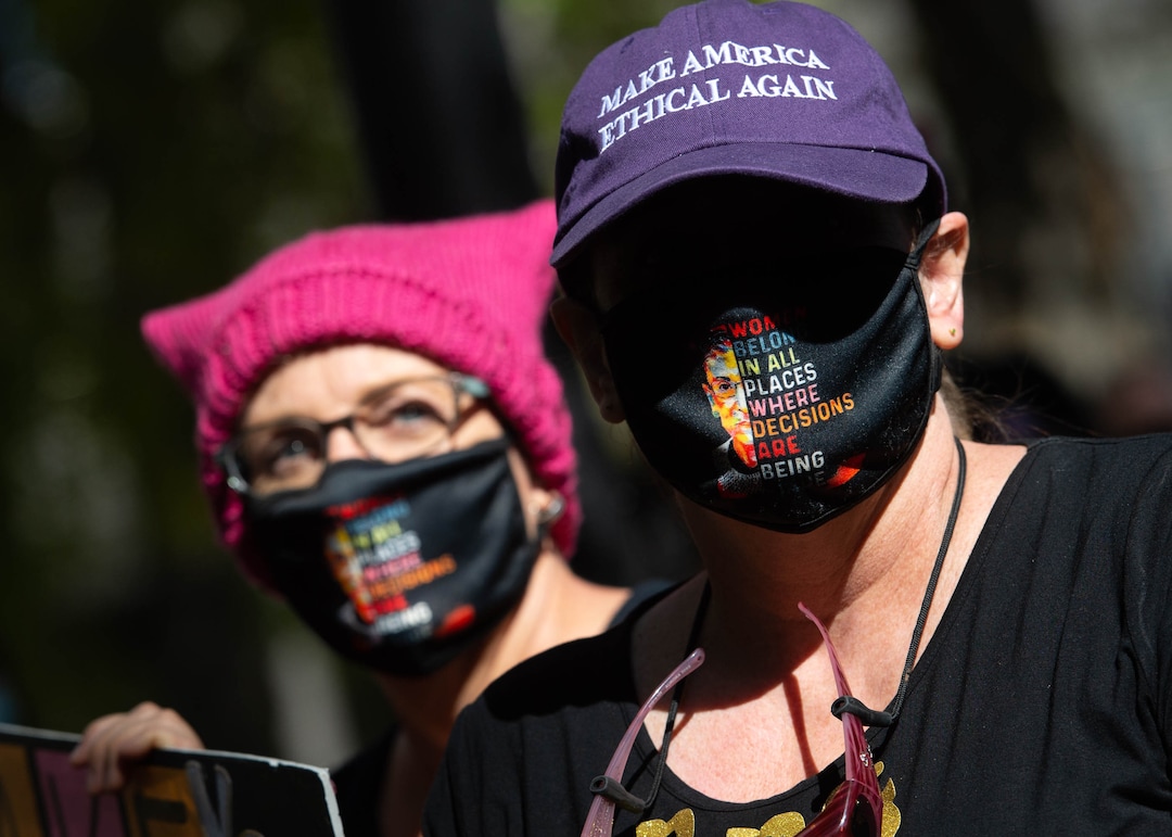 (Francisco Kjolseth  |  The Salt Lake Tribune) Sisters Laura, left, and Sarah Bush, listen to speakers at Salt Lake City Hall alongside demonstrators gathered for one of the Women’s March rallies happening in Washington D.C. and around the country on Saturday, Oct. 17, 2020, to signal their opposition to President Donald Trump and his agenda, including his push to fill the seat of late Supreme Court Justice Ruth Bader Ginsburg before election day.