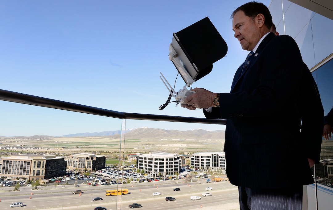 (Al Hartmann  |  The Salt Lake Tribune) 	Gov. Gary R. Herbert uses remote control to pilot a drone in Lehi Wednesday April 25 to get a view of  the Utah Department of Transportation’s (UDOT) I-15 Tech Corridor project in Lehi for a pre-construction site tour. The project will widen I-15 with two new lanes in each direction from Lehi Main Street to S.R. 92. It will also alleviate east-west congestion in this busy area by building a bridge at Triumph Boulevard, adding a one-way frontage road system from 2100 North to S.R. 92 and reconstructing those two interchanges. In addition, the project will construct 17 bridges and include several bike and pedestrian improvements.  