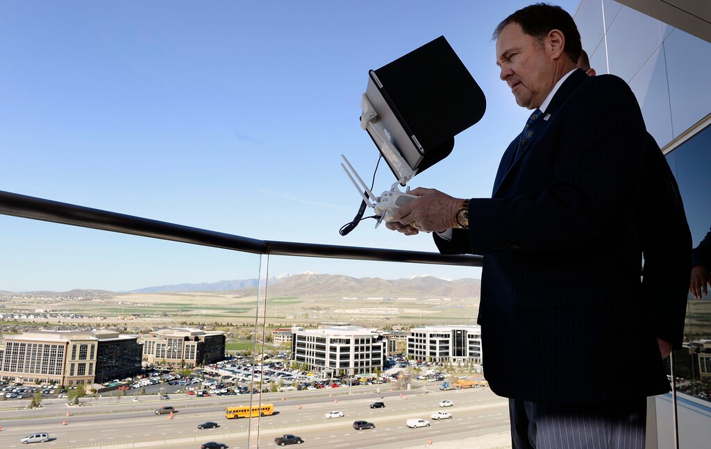 (Al Hartmann | The Salt Lake Tribune) Gov. Gary R. Herbert uses remote control to pilot a drone in Lehi Wednesday April 25 to get a view of the Utah Department of Transportation’s (UDOT) I-15 Tech Corridor project in Lehi for a pre-construction site tour. The project will widen I-15 with two new lanes in each direction from Lehi Main Street to S.R. 92. It will also alleviate east-west congestion in this busy area by building a bridge at Triumph Boulevard, adding a one-way frontage road system from 2100 North to S.R. 92 and reconstructing those two interchanges. In addition, the project will construct 17 bridges and include several bike and pedestrian improvements.