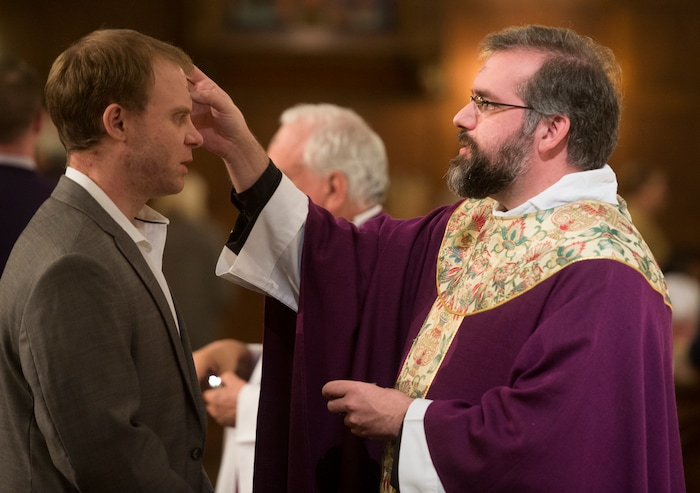 (Rick Egan | The Salt Lake Tribune) The Reverend Christopher P. Gray, dispenses ashes, on the forehead of Matt Fry, during the Ash Wednesday Mass, at the Cathedral of The Madeleine, Wednesday, Feb. 14, 2018.