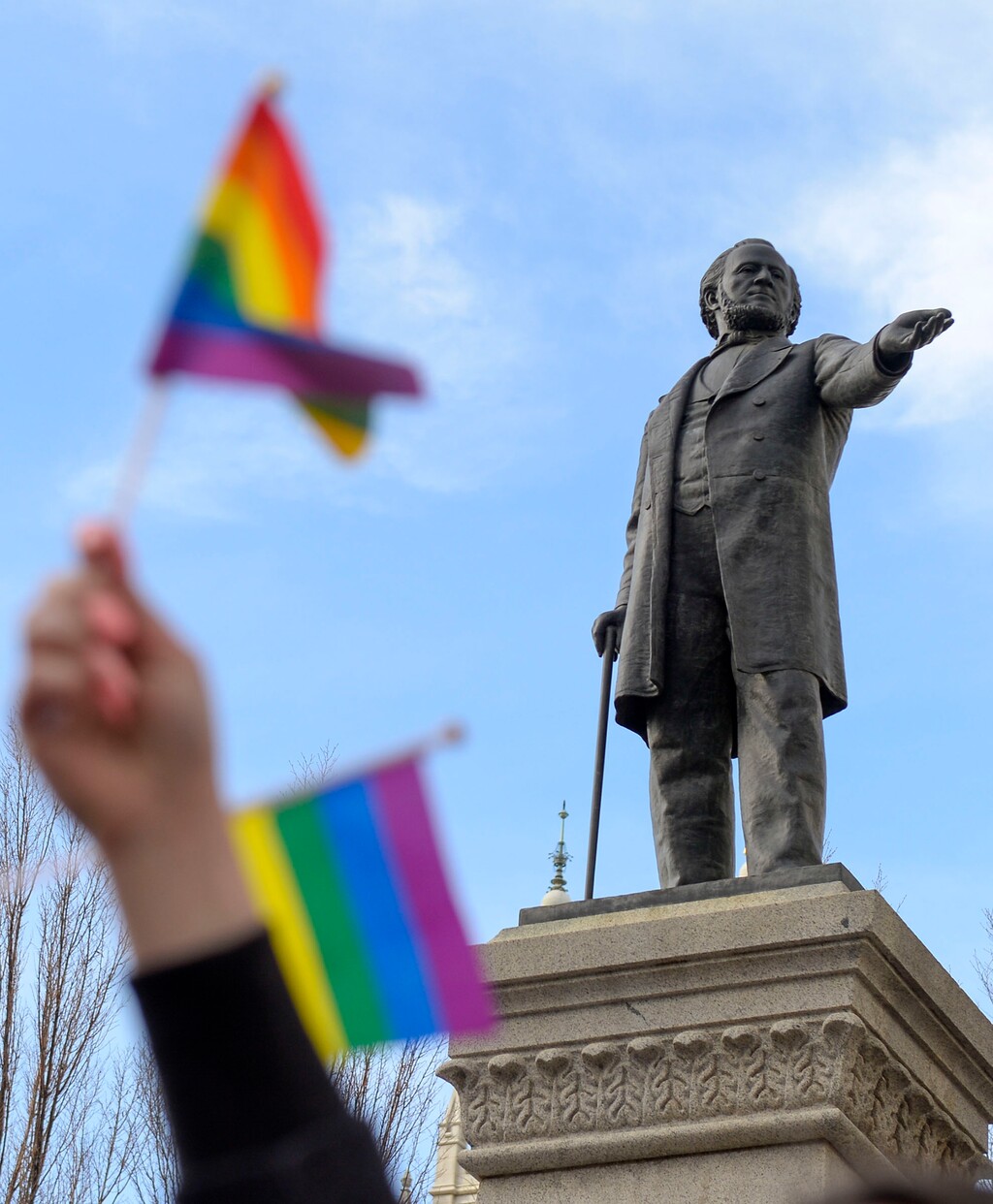 (Leah Hogsten  |  The Salt Lake Tribune) Pride flag flies in front of the Brigham Young Monument in downtown Salt Lake City in 2020. New research out of Utah State University shows religiosity can improve the happiness of some LGBTQ Latter-day Saints — at least for a while.