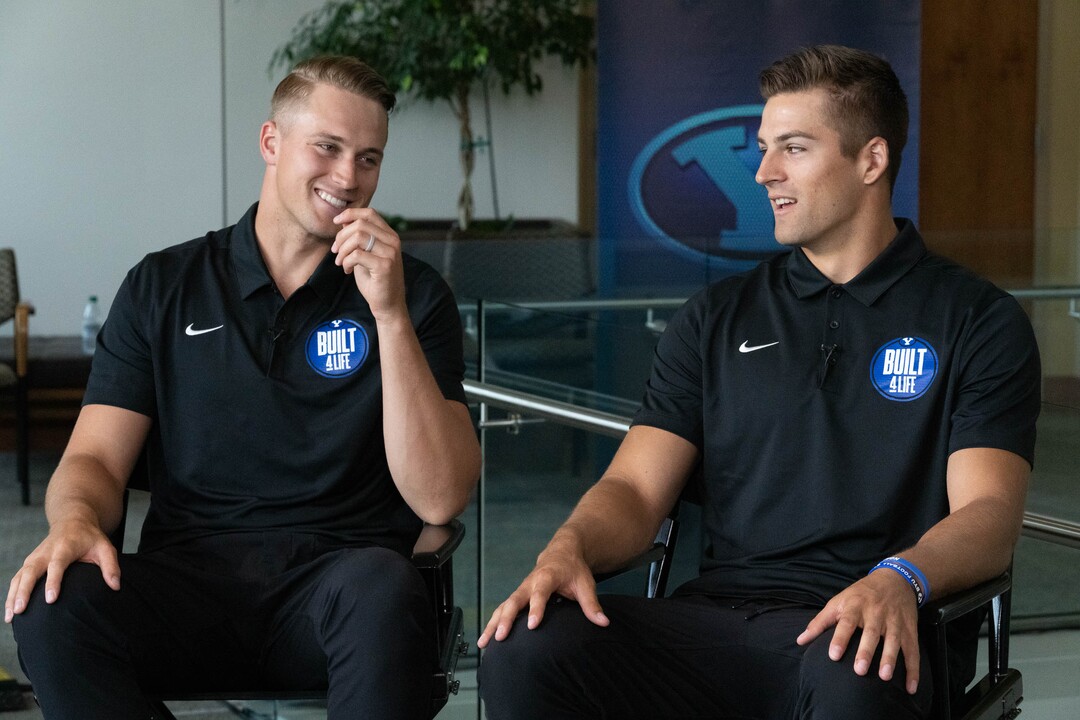(Francisco Kjolseth | The Salt Lake Tribune) Brothers Baylor Romney, left, and Gunner argue over the details of family stories being competitive with one another as they join BYU football coaches, players and staff participating in BYU Football Media Day in the BYU Broadcasting Building in Provo on Thursday, June 17, 2021.