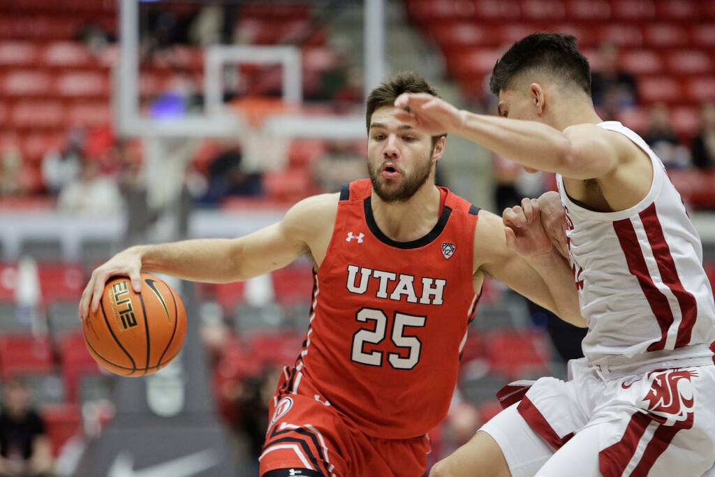 Utah guard Rollie Worster, left, controls the ball while defended by Washington State guard Dylan Darling during the first half of an NCAA college basketball game, Sunday, Dec. 4, 2022, in Pullman, Wash. (AP Photo/Young Kwak)