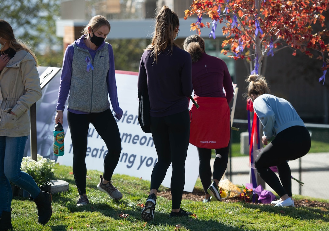 (Francisco Kjolseth  |  The Salt Lake Tribune) Members of the track and field team place flowers at the base of the tree that was planted in honor of University of Utah student and track athlete Lauren McCluskey on Thursday, Oct. 22, 2020, next to the track. A memorial walk was held on the two-year anniversary of her murder.