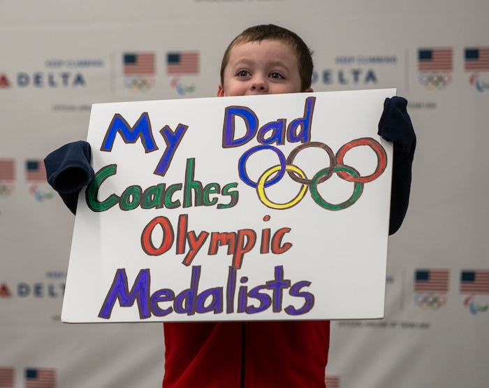 (Rick Egan | The Salt Lake Tribune) Four-year-old Thomas Stuart, holds a sign as he waits for his dad, Andrew Stuart, a conditioning coach for the U.S. speedskating team, to arrive at the Salt Lake City International Airport, on Monday, Feb. 21, 2022.