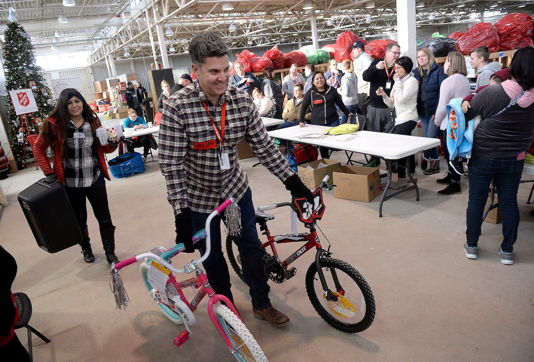 (Al Hartmann  |  The Salt Lake Tribune) 	Salt Lake School District volunteer Brian Conley wheels two new bikes to fill a Christmas present order for a family in need at the Salvation Army's Angel Tree distribution warehouse at the Utah State Fairgrounds.   Needy families living in the Salt Lake School District picked up their bags of presents Friday Dec. 22, just in time for Christmas. 