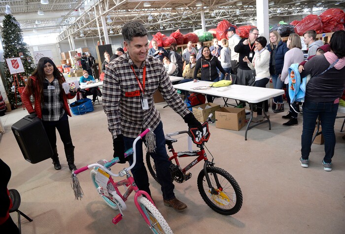 (Al Hartmann  |  The Salt Lake Tribune) 	Salt Lake School District volunteer Brian Conley wheels two new bikes to fill a Christmas present order for a family in need at the Salvation Army's Angel Tree distribution warehouse at the Utah State Fairgrounds.   Needy families living in the Salt Lake School District picked up their bags of presents Friday Dec. 22, just in time for Christmas. 