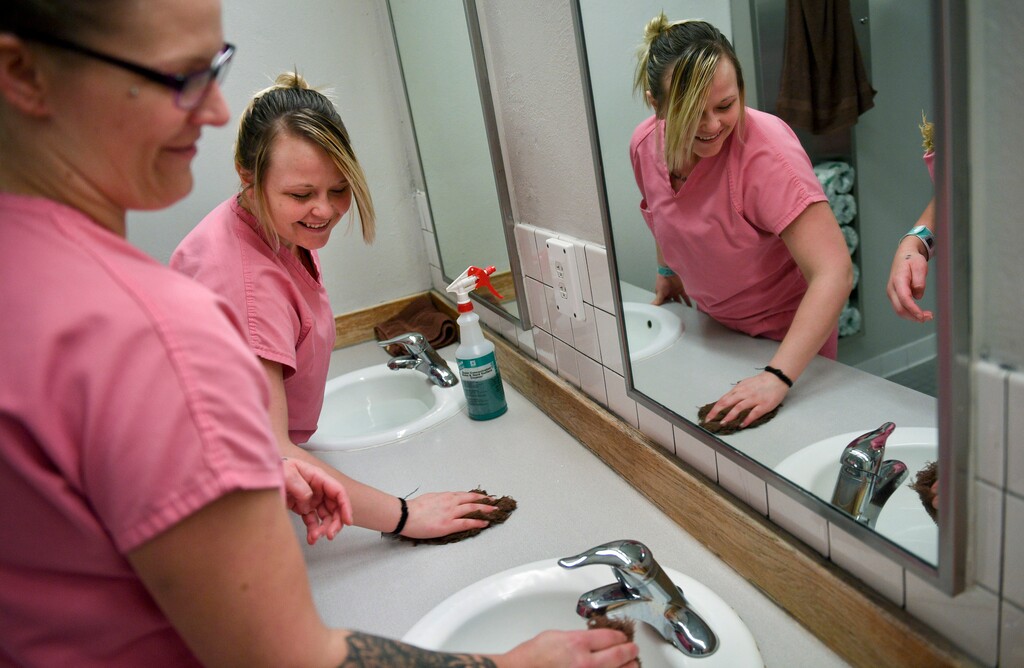 (Isaac Hale | The Daily Herald | The Associated Press) In this Wednesday, Jan. 24, 2018 photo, Marcella Austin, center, of Salt Lake City, cleans a bathroom with Lisa Dupuy, of Pleasant Grove,  at the Utah County Jail in Spanish Fork, Utah. To qualify for the Chain Breakers program, individuals must also be inmate workers.