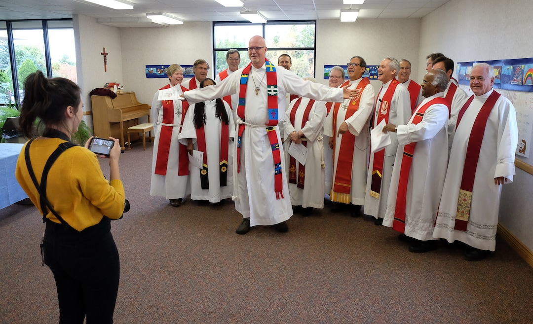 (Francisco Kjolseth  |  The Salt Lake Tribune)  Rev. David Nichols tries to steal the spotlight for a group photo as Lutheran and Catholic priests gather at Zion Evangelical Lutheran Church in Salt Lake City for an ecumenical prayer service. 