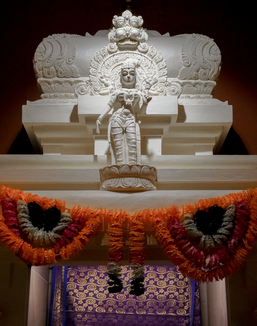 Leah Hogsten  |  The Salt Lake Tribune  Niladevi Andal is depicted with stylized hair and is decorated with strings of pearls. She carries a parrot, a symbol of the discerning mind and a lotus in her hand.  Artisans from around the world spent two years hand-carving deities in the Sri Ganesha Hindu Temple in South Jordan. 