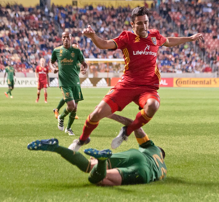 (Michael Mangum  |  Special to the Tribune)  Real Salt Lake defender Tony Beltran (2) leaps over a sliding Portland Timbers defender Liam Ridgewell (24) during their MLS match at Rio Tinto Stadium in Sandy, UT on Saturday, September 16, 2017.