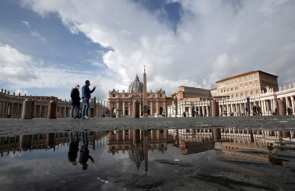 FILE - In this Sunday, Jan. 31, 2021 file photo, people are reflected on a puddle as they walk in St. Peter's Square, at the Vatican. The Vatican is taking Pope Francis’ pro-vaccine stance very seriously: Any Vatican employee who refuses to get a coronavirus shot without valid medical reason risks being fired.
A Feb. 8 decree signed by the governor of the Vatican City State sparked heated debate Thursday, Feb. 18, 2021 since its provisions go well beyond the generally voluntary nature of COVID-19 vaccinations in Italy and much of the rest of the world. (AP Photo/Alessandra Tarantino, File)