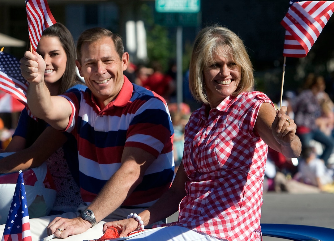 (Al Hartmann  | Tribune file photo)  Provo Mayor John Curtis with wife Sue wave flags as they lead the Grand Parade on Monday July 5, 2010 through the streets of Provo.  The Grand Parade is the  largest of its kind in the state of Utah Ð highlighting freedom and promoting patriotism featuring local marching bands,  floats,  and giant helium balloons.   An estimated 250,000 spectators were expected for the parade. 