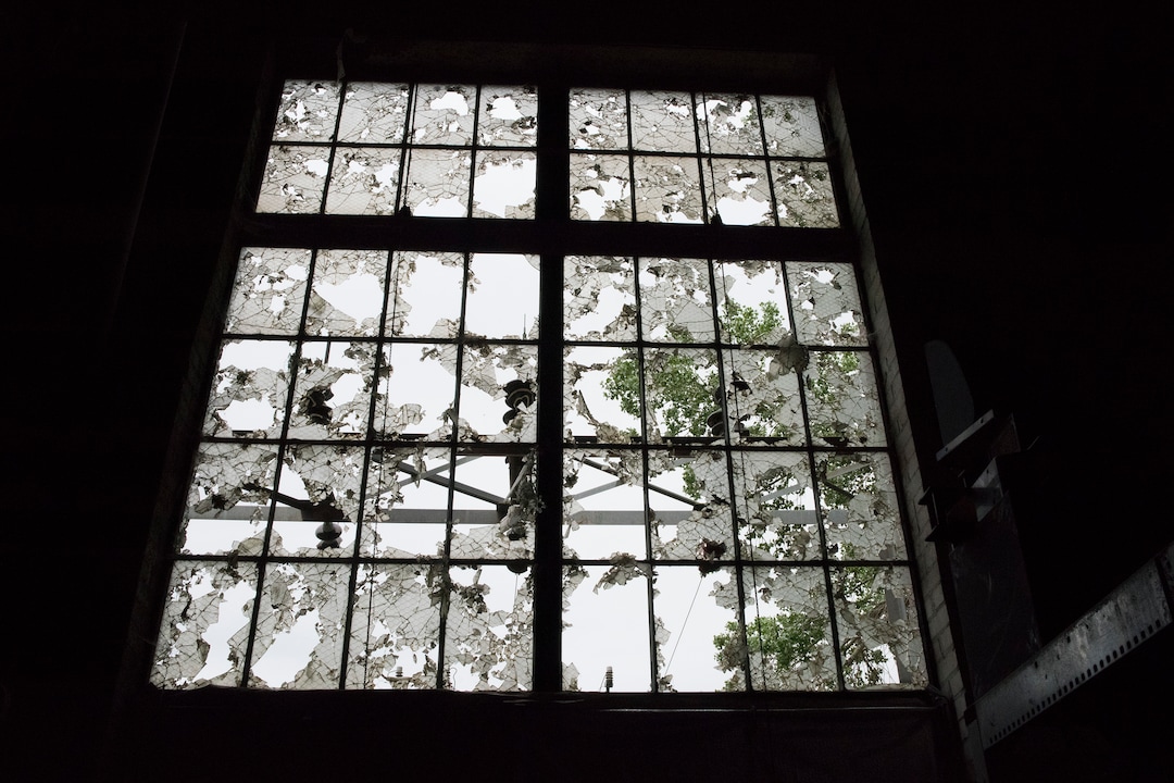 (Briana Scroggins  |  The Utah Investigative Journalism Project) Shattered window panes cling to a window in the Swift building in Ogden on Thursday, May 16, 2019. The EPA started site clean up on April 1 and plan to finish by August 2019.