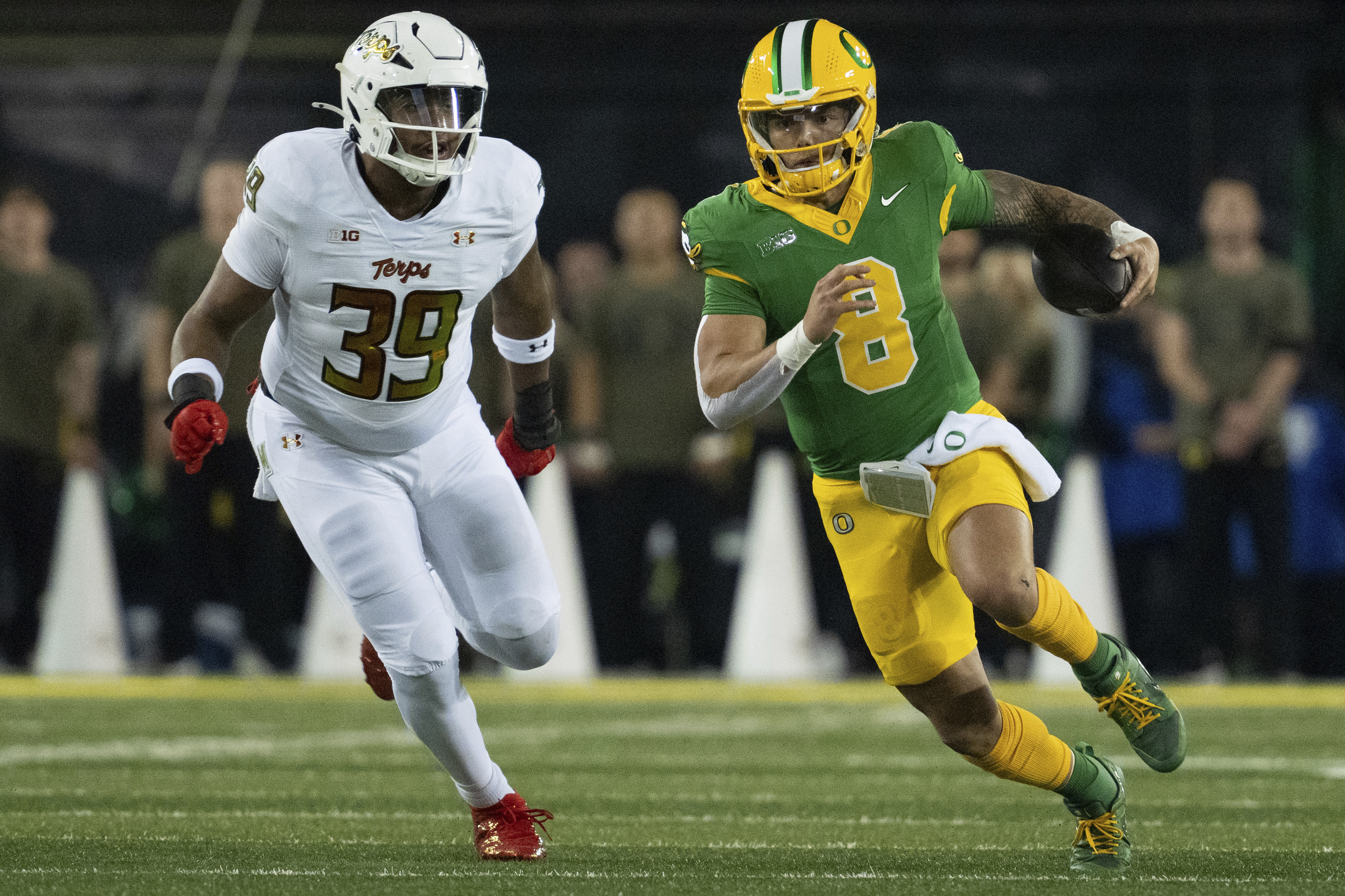 Oregon quarterback Dillon Gabriel (8) runs the ball as Maryland defensive lineman Daniel Owens (39) defends during the second half of an NCAA college football game on Saturday, Nov. 9, 2024, in Eugene, Ore. Oregon won 39-18. (AP Photo/Jenny Kane)