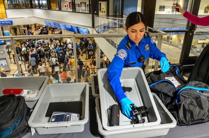 (Steve Griffin  |  The Salt Lake Tribune)  TSA agent Suzanna Coria shows some of the electronic devises that need to be in their own bin under new stronger security procedures  at the Salt Lake International Airport and five other Utah airports Thursday October 5, 2017. 