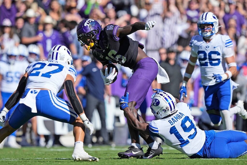 (LM Otero | AP) TCU wide receiver Dylan Wright (16) works for extra yards after making a catch against BYU defenders Mory Bamba (19) and Preston Rex (27) on Saturday in Fort Worth, Texas.