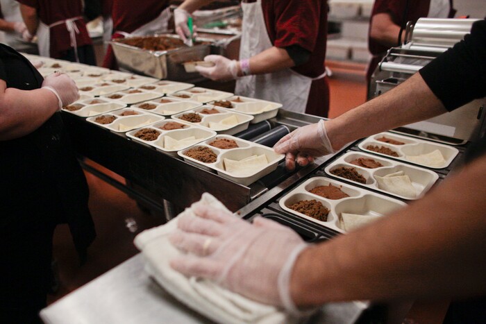 In this photo taken Feb. 7, 2018, inmates and staff prepare meals in the kitchen at the Utah County Jail for the inmates and also for the Utah County Meals on Wheels program in Spanish Fork, Utah. (Evan Cobb/The Daily Herald via AP)