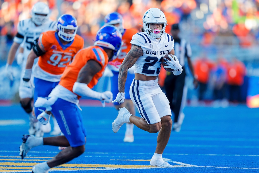 Utah State wide receiver Kyrese White (23) runs with the ball against the Boise State defense after a reception in the first half of an NCAA college football game, Saturday, Oct. 5, 2024, in Boise, Idaho. . (AP Photo/Steve Conner)