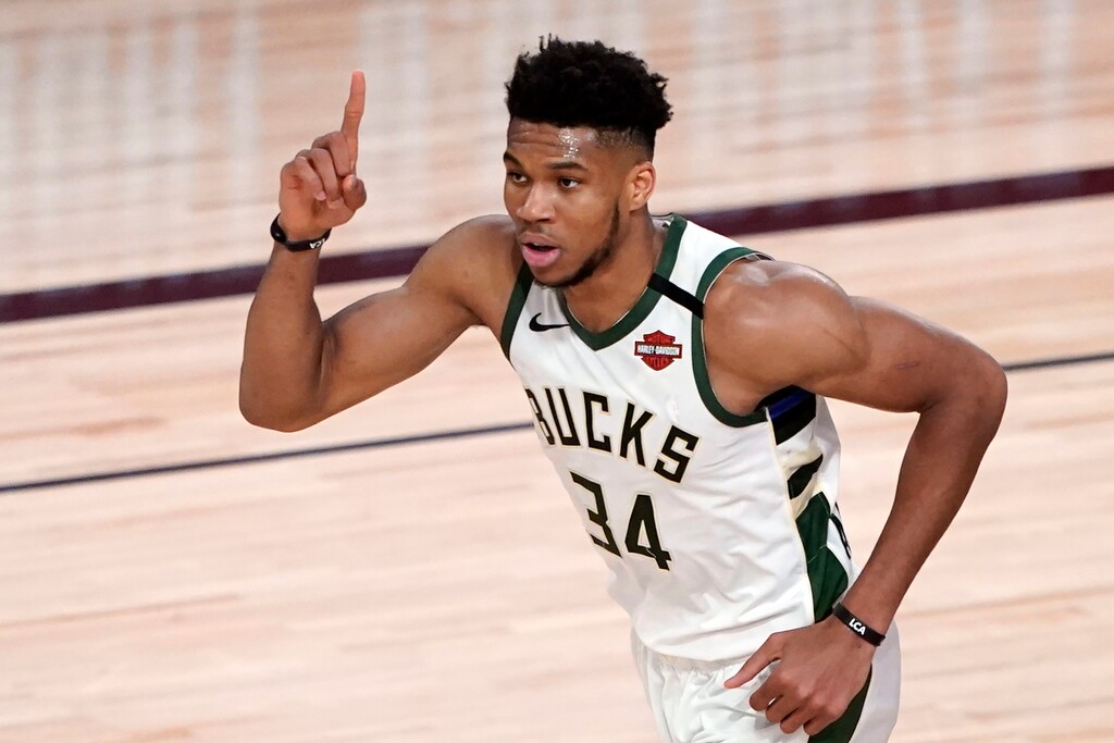FILE - In this Saturday, Aug. 29, 2020 file photo, Milwaukee Bucks' Giannis Antetokounmpo (34) celebrates after a dunk against Orlando during the first half of an NBA basketball first round playoff game in Lake Buena Vista, Fla. Giannis Antetokounmpo praised the “amazing” moves the Bucks have made to improve their team, but the two-time reigning MVP didn’t indicate whether he would sign their supermax contract extension offer. Right now I’m not focusing on that,” Antetokounmpo said Wednesday, Dec. 9, 2020. (AP Photo/Ashley Landis, File)