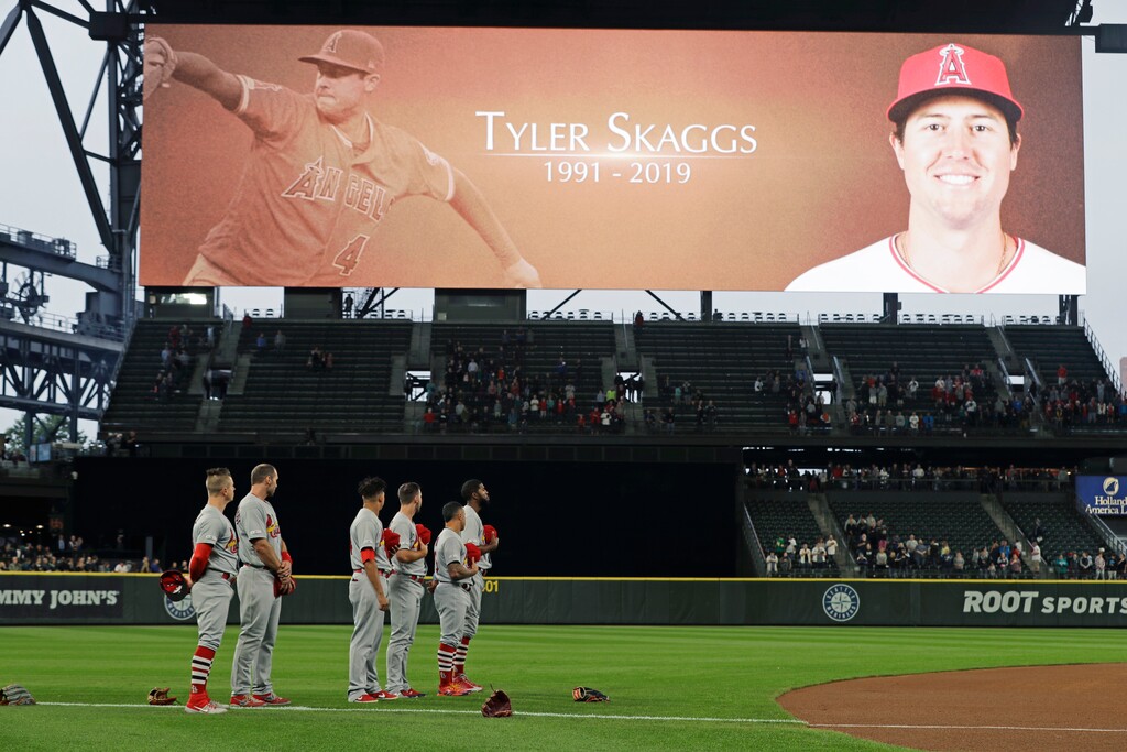 (AP Photo/Ted S. Warren) St. Louis Cardinals players stand on the field at T-Mobile Park in Seattle, Tuesday, July 2, 2019 during a moment of silence in memory of Los Angeles Angels pitcher Tyler Skaggs, prior to the Cardinals' baseball game against the Seattle Mariners. Skaggs was found unresponsive in his hotel room in Texas on Monday.