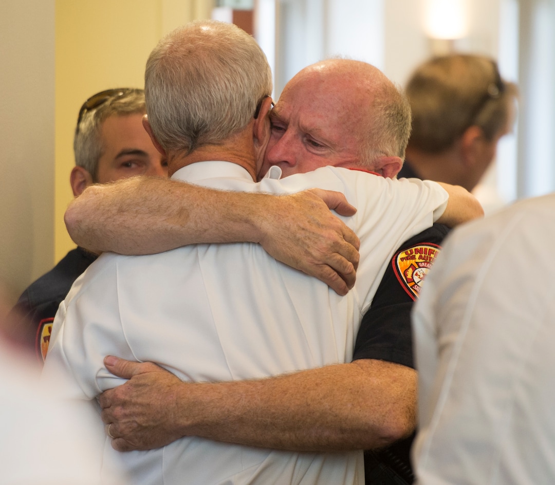 (Rick Egan  |  The Salt Lake Tribune)       Batt. Chief Duane Woolsey with Unified Fire hugs Assistant Chief Mike Watson,  before a press conference at Draper City Hall about Matt Burchett, 42, who died fighting wildfires in California. Tuesday, Aug. 14, 2018.