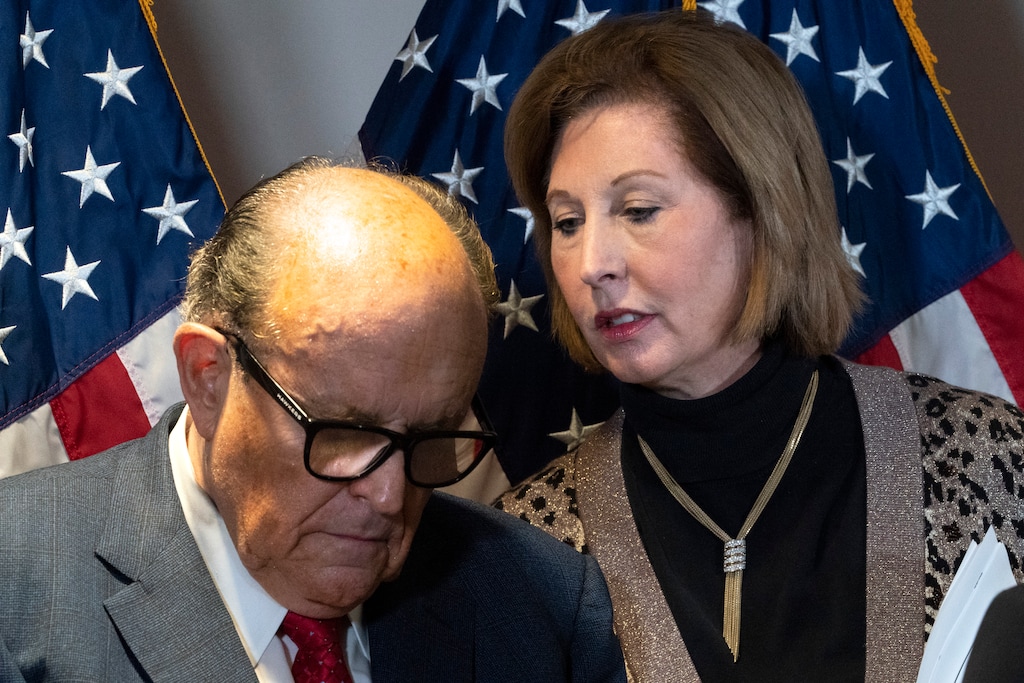Former Mayor of New York Rudy Giuliani, left, listens to Sidney Powell, both lawyers for President Donald Trump, during a news conference at the Republican National Committee headquarters, Thursday Nov. 19, 2020, in Washington. (AP Photo/Jacquelyn Martin)
