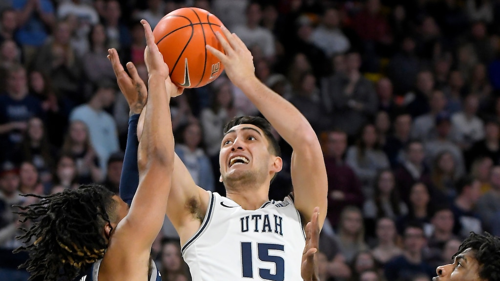 Utah State guard Abel Porter (15) shoots as Nevada guard Jazz Johnson (22) and guard Lindsey Drew (14) defend during the first half of an NCAA college basketball game Saturday, Jan. 11, 2020, in Logan, Utah. (Eli Lucero/The Herald Journal via AP)