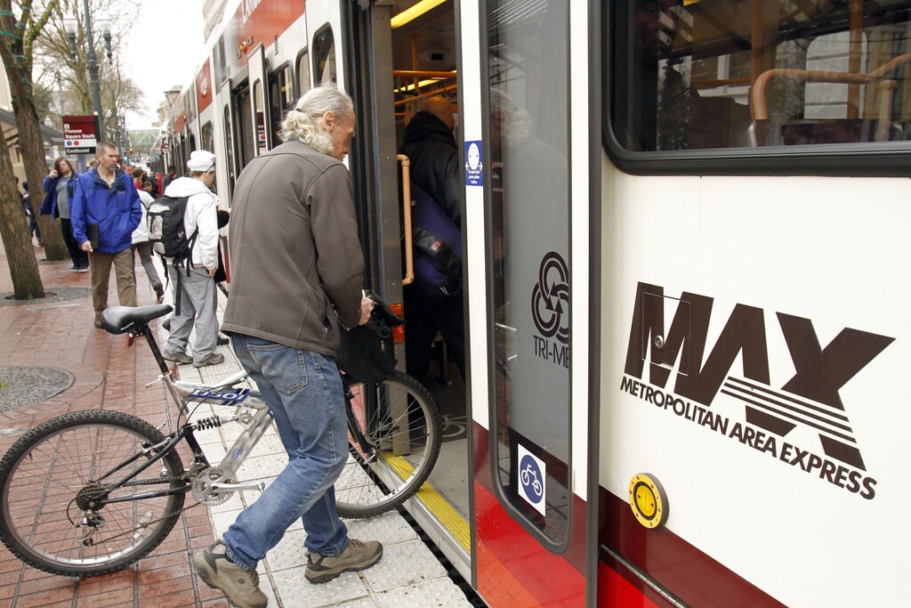 FILE--In this April 11, 2012, file photo, passengers board a TriMet light rail train in downtown Portland, Ore. (AP Photo/Don Ryan, file)