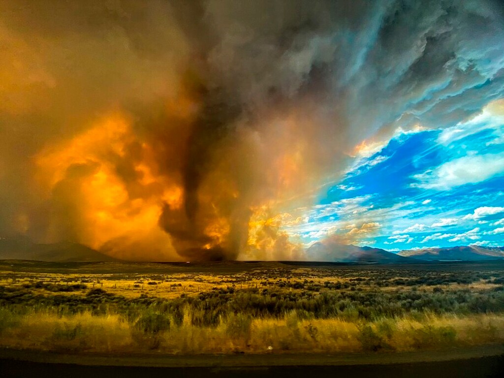 (Katelynn & Jordan Hewlett via AP) A funnel appears in a thick plume of smoke from the Loyalton Fire is seen in Lassen County, Calif., Saturday, Aug. 15, 2020. A wildfire in Northern California on Saturday spawned at least one fire tornado that prompted the National Weather Service to issue a tornado warning. The Loyalton Fire in Lassen County, Calif., burned intensely amid hot and dry conditions on Saturday afternoon.