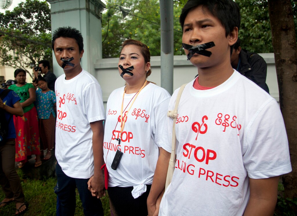 FILE - In this July 12, 2014, file photo, Myanmar journalist Thet Oo Maung, known as Wa Lone, right, stands with other journalists with their mouths taped, symbolizing the government's crackdown on media, in Yangon, Myanmar. Wa Lone is one of two reporters Myanmar is set to put on trial this week after they were charged under a colonial-era state secrets act, in a case that highlights growing concerns about press freedom in the country. (AP Photo/Khin Maung Win, File)