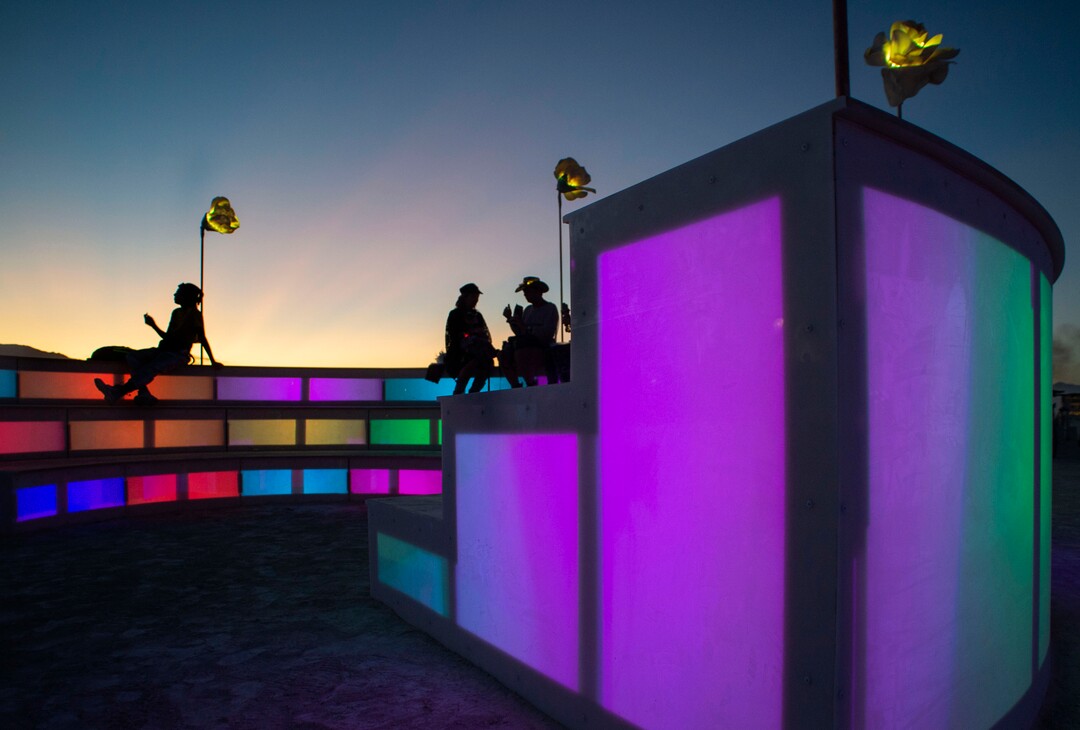 (Rick Egan  |  The Salt Lake Tribune)  Burning Man revealers rest on the ulluminated steps "E Pluribus Unum: Out of Many One" by Kelly Smith Cassidy, at dusk, at Burning Man, Friday, Aug. 30, 2019.