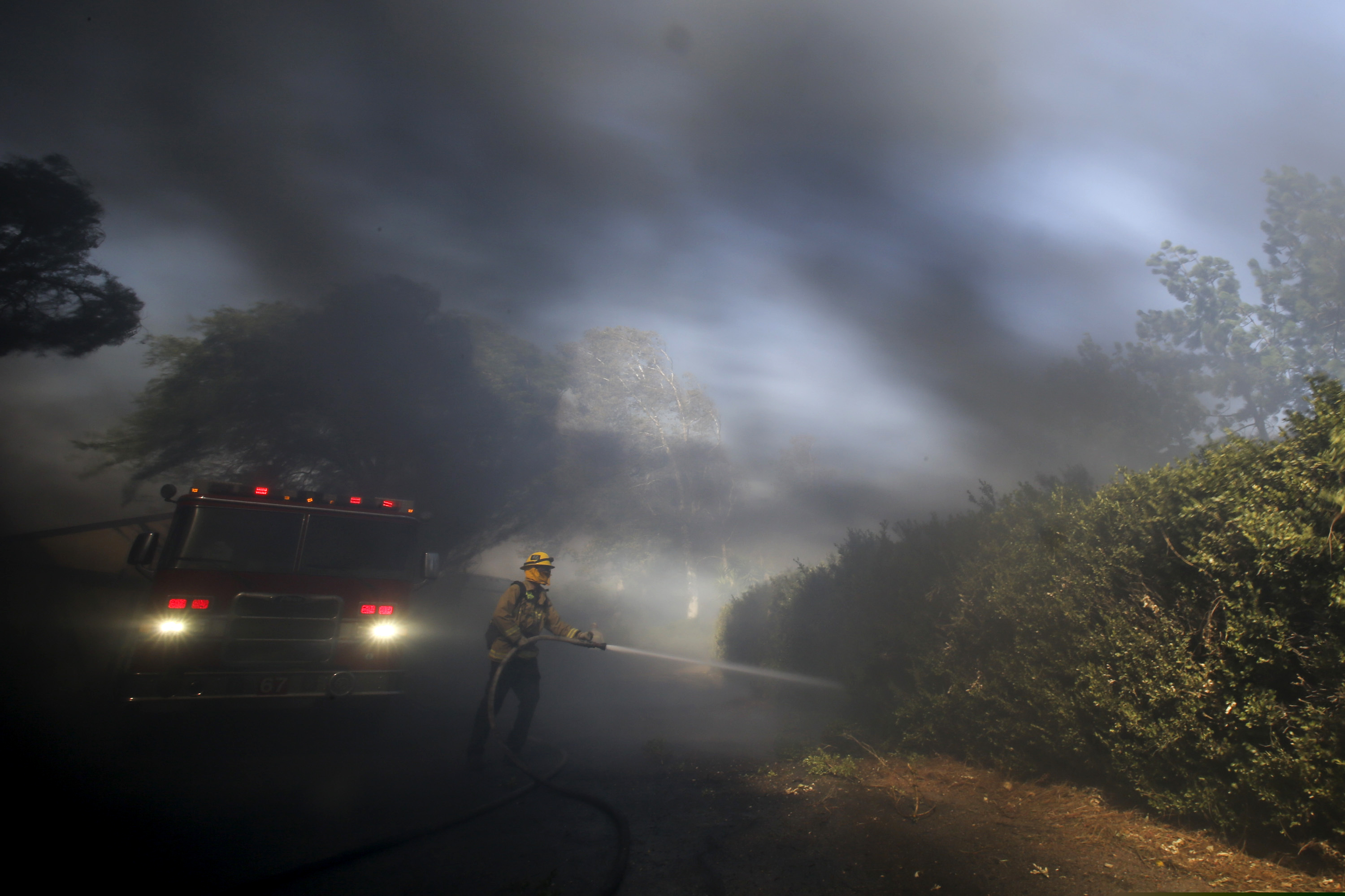 (Ringo H.W. Chiu | AP) Firefighter Brett Reed battles a wildfire near a ranch in Simi Valley, Calif., Wednesday, Oct. 30, 2019.