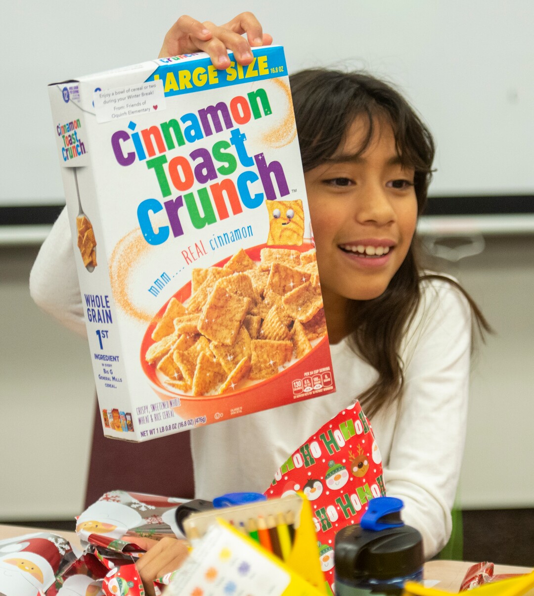 (Rick Egan  |  The Salt Lake Tribune)   Laylani Eontalez, 3rd grade, shows her classmates the box of cereal she opened. Ms. Worthington the principal, surprised all 650 students at her school with the gift-wrapped boxes of cereal, at Oquirrh Elementary in West Jordan, Thursday, Dec. 20, 2018.